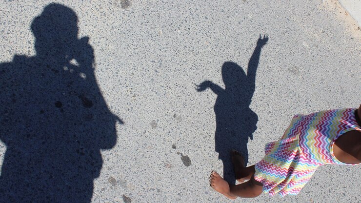 Foto sombra de pessoa com menina de pé na calçada
