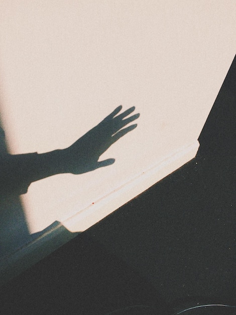 Foto sombra de pessoas com a mão na parede