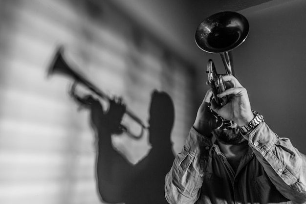 Foto sombra de um músico de jazz tocando trompete. conceito de música jazz.