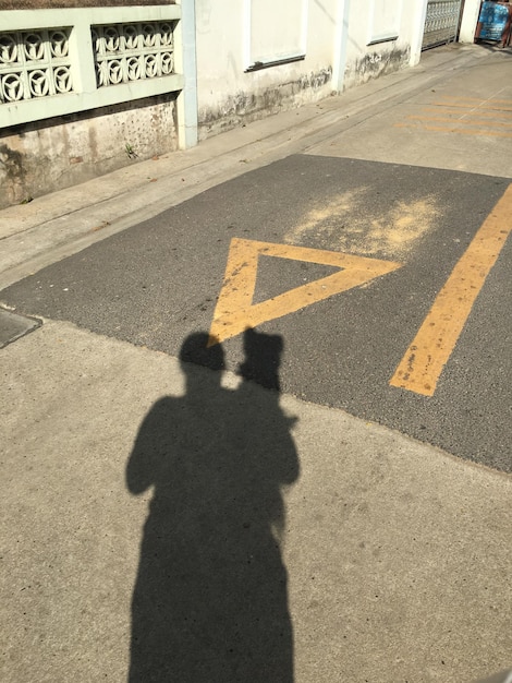 Foto sombra de uma pessoa na estrada da cidade