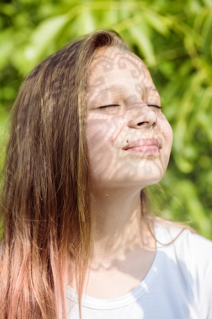 Foto la sombra del hermoso encaje en la cara de una niña adolescente