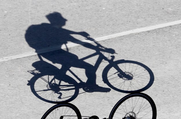 Foto sombra de un hombre en bicicleta en la carretera