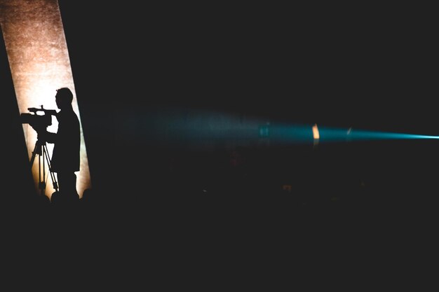 Foto sombra de un hombre en la pared en el cuarto oscuro