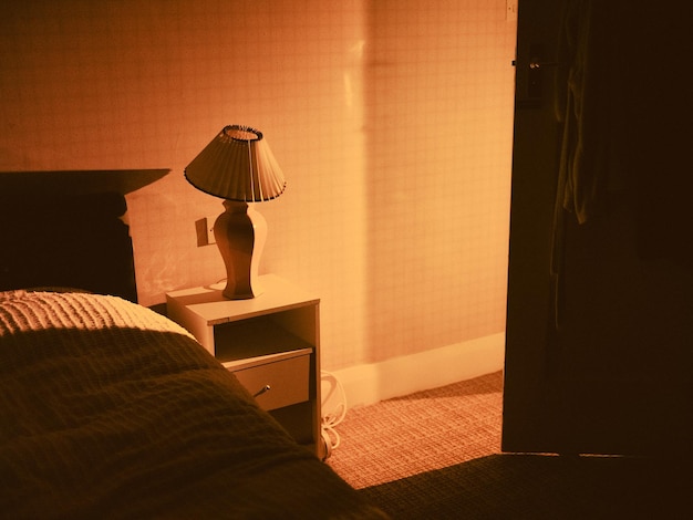 Sombra de la lámpara junto a la cama en casa