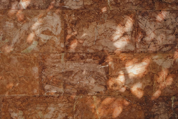 Sombras en una pared hecha de grandes azulejos abstractos marrones Textura de fondo para el diseño