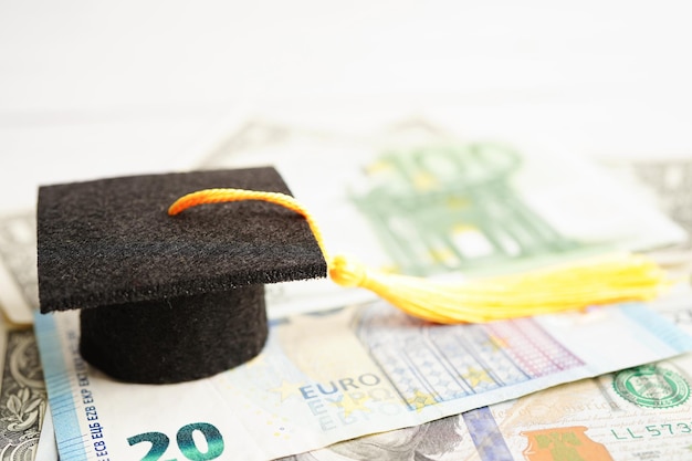 Sombrero de brecha de graduación en billetes de euro y dólar estadounidense dinero Educación tasa de estudio aprendizaje enseñar concepto