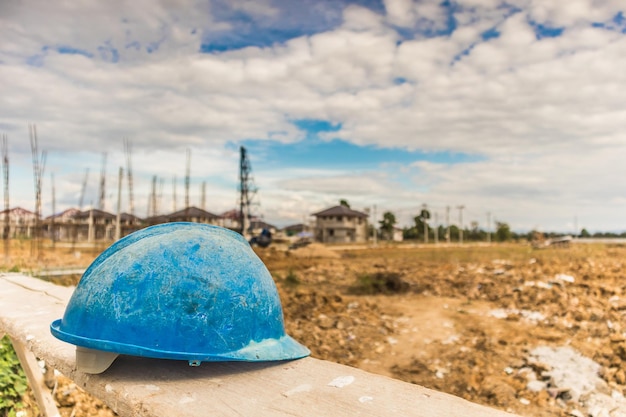 Sombrero duro azul en el sitio de construcción de la construcción de viviendas