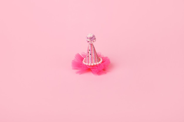 Sombrero de fiesta de cono para niños sobre fondo rosa, ambiente festivo y concepto de cumpleaños