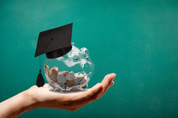 Sombrero de graduación en un frasco de vidrio con dinero en mano