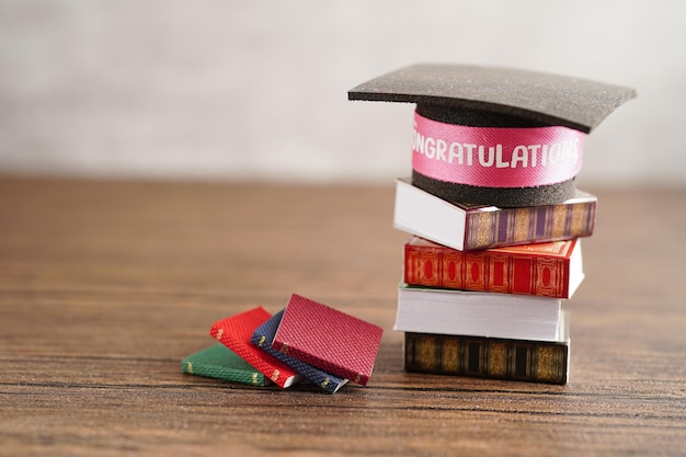 Sombrero de graduación en libro con espacio de copia aprendizaje concepto de educación universitaria