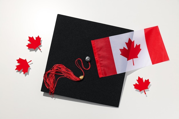 Foto sombrero de graduado con bandera canadiense en un fondo claro