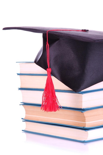 Sombrero de graduado con libros aislados en blanco