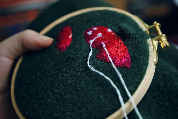 Sombrero de hongo bordado a mano para niñas en aro sobre material verde concepto de costura hobby ocio clo ...