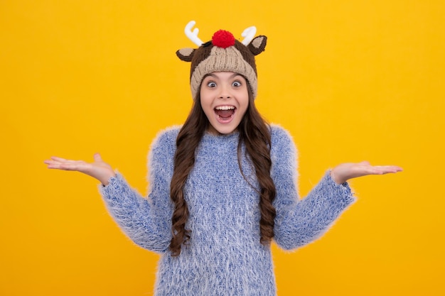 Sombrero de invierno Concepto de temporada fría Accesorio de moda de invierno para niños Niña adolescente con sombrero de punto cálido Cara emocionada emociones alegres de niña adolescente