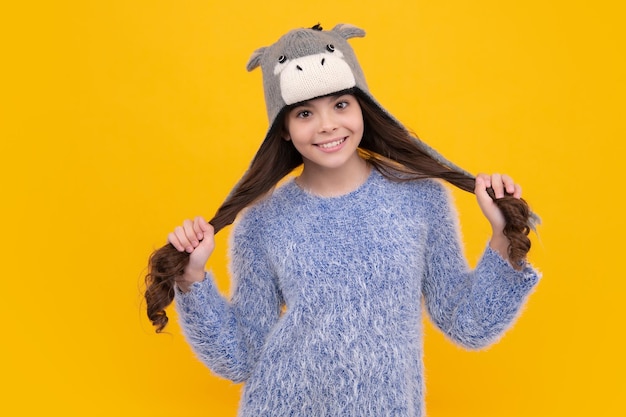 Sombrero de invierno Concepto de temporada fría Accesorio de moda de invierno para niños Niña adolescente con sombrero de punto cálido Cara feliz emociones positivas y sonrientes de niña adolescente