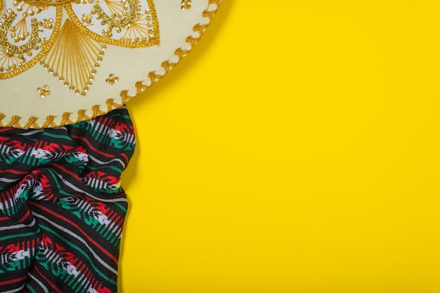 Foto sombrero mariachi y serape en fondo amarillo concepto de independencia mexicano fondo cinco de mayo