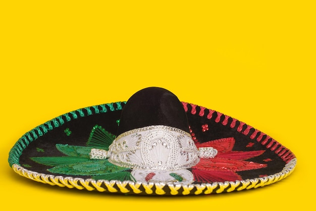 Foto sombrero mariachi tricolor sobre fondo amarillo fondo festivo del cinco de mayo