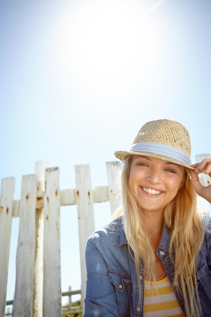 Sombrero de mujer y retrato en el fondo del cielo azul del sol o destello de lente de maqueta El parque de moda de verano y la mujer se relajan en la cerca del campo naturaleza y libertad con felicidad en el medio ambiente maqueta o sonrisa