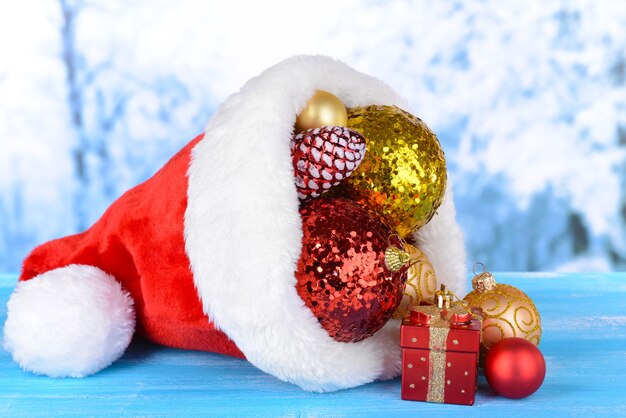 Sombrero de Navidad con adornos navideños en la mesa sobre fondo claro