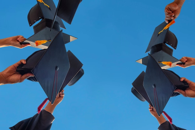 Sombrero negro de los graduados flotando en el cielo.