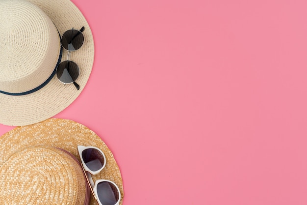 Sombrero de paja femenino y gafas de sol para la vista superior de vacaciones en la playa