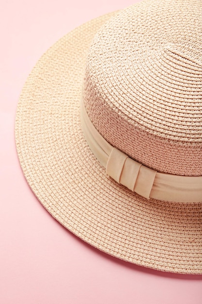 Sombrero de paja de moda de mujer sobre fondo púrpura