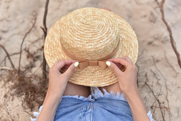 Sombrero de paja en mujer las manos sobre las rodillas en viajes al libre ropa para la cabeza para climas cálidos ropa para clima cálido | Foto Premium