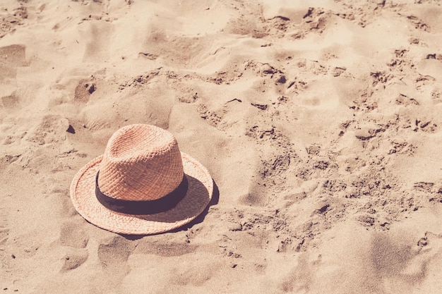 Sombrero de paja en la playa de arena. Concepto de verano y viajes.