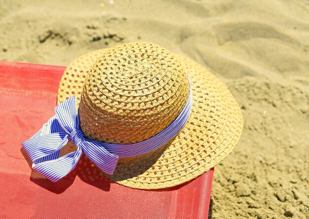 Foto sombrero de paja en la silla de sol en la playa en verano