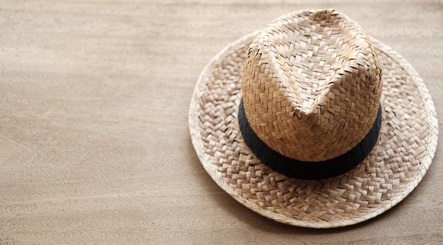 Sombrero de paja sobre fondo de madera y espacio de copia