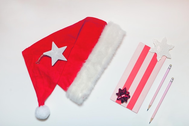 Sombrero de Papá Noel y carta con lápiz Lista de deseos de Año Nuevo o Navidad Banner de vacaciones desde arriba