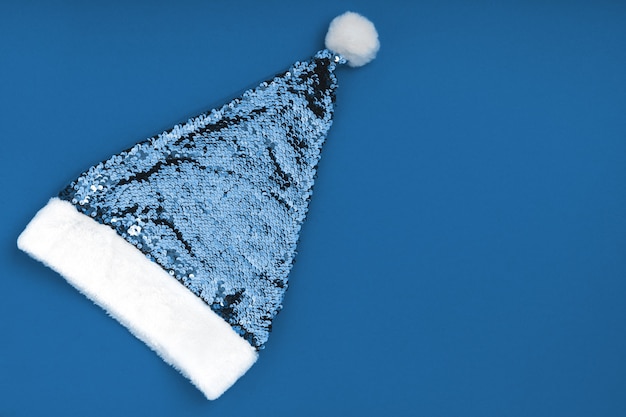 Sombrero de Papá Noel dorado brillante de Navidad sobre fondo azul. Fondo de vacaciones de año nuevo de Navidad Navidad.