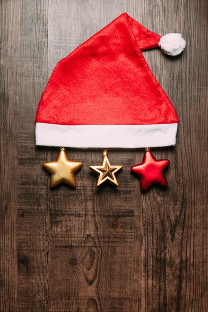 Sombrero de Papá Noel con las estrellas metálicas en fondo de madera.