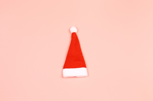 Sombrero de Papá Noel sobre un fondo rosa. Fondo escandinavo navideño minimalista con lugar vacío para texto