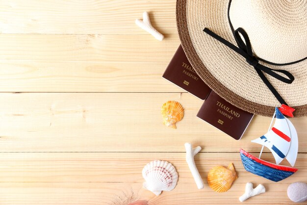 Sombrero de playa, velero y gafas sobre fondo de madera en el verano de Asia