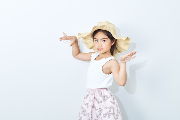 Sombrero que lleva de la muchacha delgada asiática en el fondo blanco.