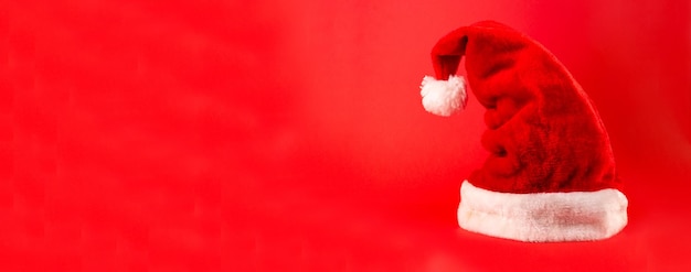 Sombrero rojo de Santa Claus aislado sobre fondo rojo Feliz año nuevo concepto flatlay copyspace