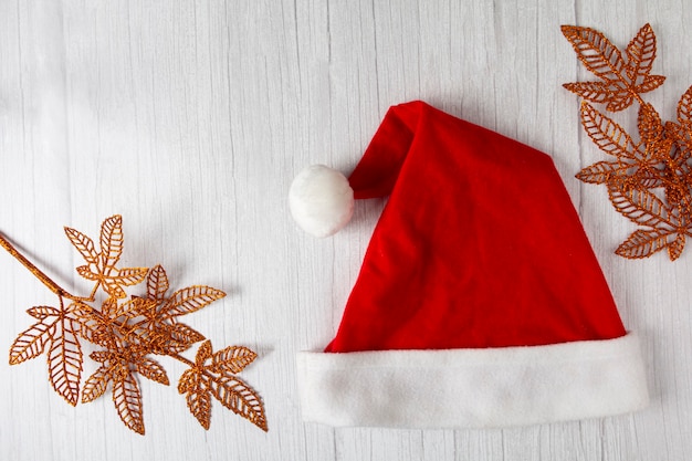 Sombrero de Santa Claus con adornos navideños en mesa de madera.