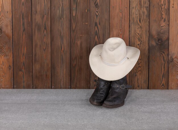 Foto sombrero de vaquero y botas en el suelo de madera