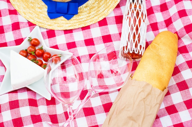 Foto sombrero, vasos, pan y queso sobre mantel rojo