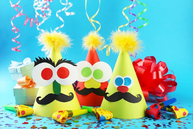 Foto sombreros de fiesta divertidos con sopladores en fondo de color