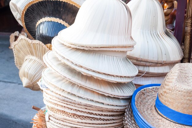 Sombreros hechos a mano tejidos con arreglo de sombreros de bambú en la tienda de artesanía del mercado