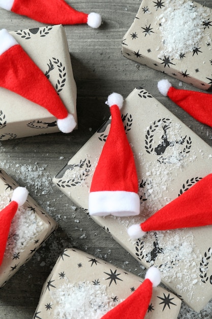 Sombreros de Papá Noel y cajas de regalo en la mesa con textura gris