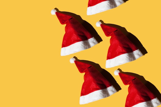 Sombreros de Papá Noel sobre un fondo amarillo