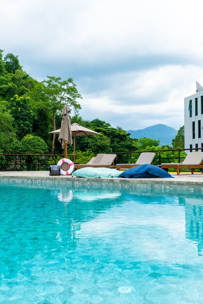 Foto sombrilla y cama de piscina alrededor de la piscina