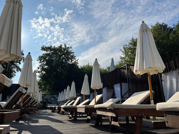 Sombrilla cerrada cerca de las camas de sol en la terraza del hotel