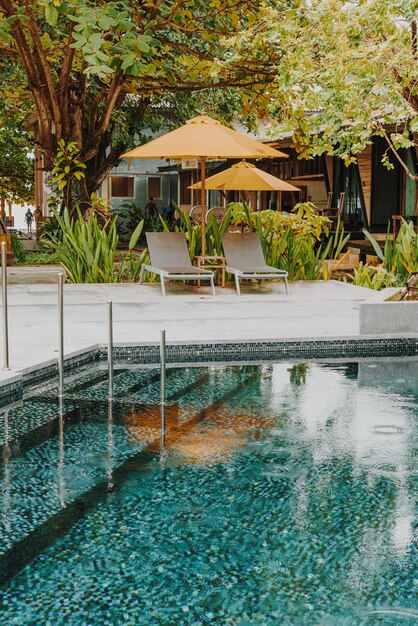 Sombrilla y decoración de la cama de la piscina alrededor de la piscina en el hotel resort