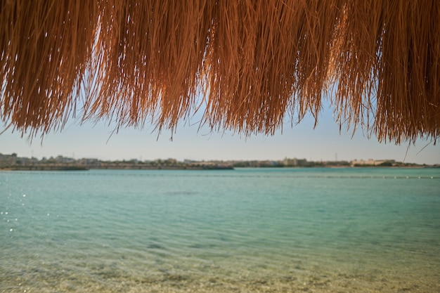 Una sombrilla de paja en una hermosa playa