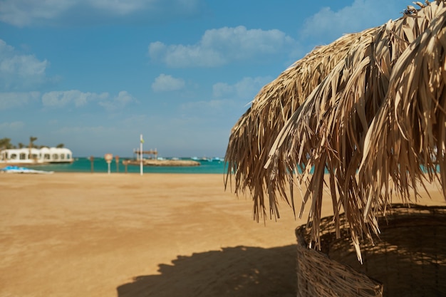 Una sombrilla de paja en una hermosa playa