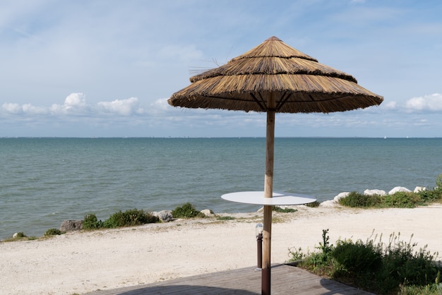 Sombrilla de paja en la playa en un día soleado